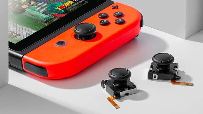 The GuliKit replacement Joy-Con Hall effect joysticks next to a Nintendo Switch with a red Joy-Con attached.