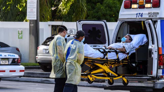 Medics transfer a patient on a stretcher from an ambulance outside of Emergency at Coral Gables Hospital where coronavirus patients are treated in Coral Gables near Miami, on July 30, 2020.