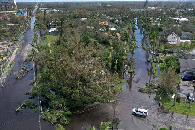 In this aerial view, vehicles make their way through a flooded area after Hurricane Ian passed through on September 29, 2022 in Fort Myers, Florida.