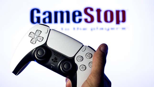 Someone holds a PS5 DualSense in front of a GameStop logo. 