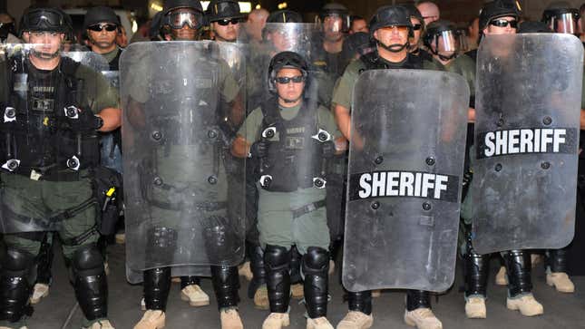 Sheriff’s deputies form a defensive line against protesters outside the offices of controversial Maricopa county sheriff Joe Arpaio in Phoenix on July 29, 2010.