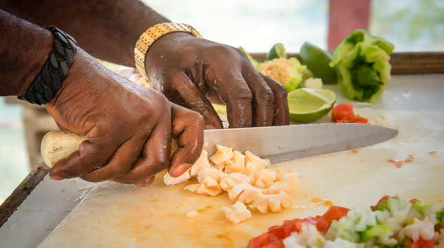 A vendor prepares conch for conch salad, another popular dish in the Bahamas.