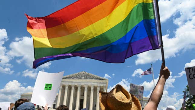 Protesters wave a Pride flag in front of the Supreme Court a day after the Court struck down Roe v. Wade.