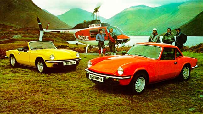 A photo of a yellow Triumph Spitfire and a red sports car parked next to a helicopter. 