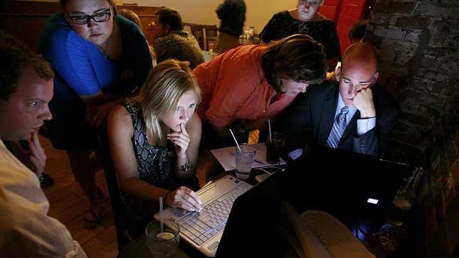 Election night journalists watching results and returns on laptop
