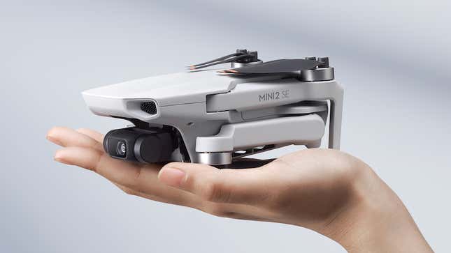 The DJI Mini 2 SE with its propellors and arms folded away, being held in the palm of a hand.