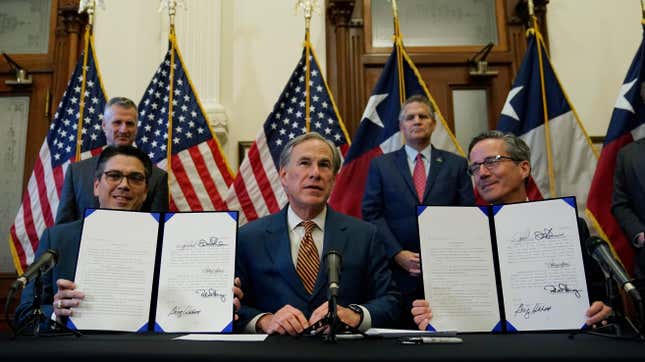 Texas Gov. Greg Abbott, center, signed legislation into law in June to reform the Electric Reliability Council of Texas (ERCOT) and weatherize and improve the reliability of the state’s power grid.