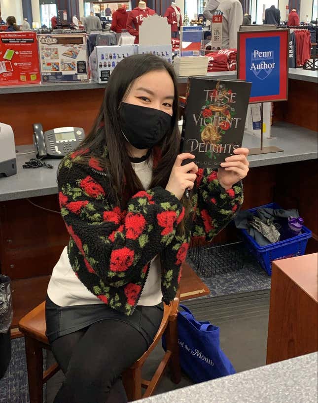 Chloe Gong poses with a copy of her best-selling 2020 debut, These Violent Delights.