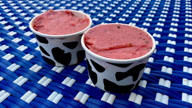 Two cups of pink dog-friendly ice cream on blue table
