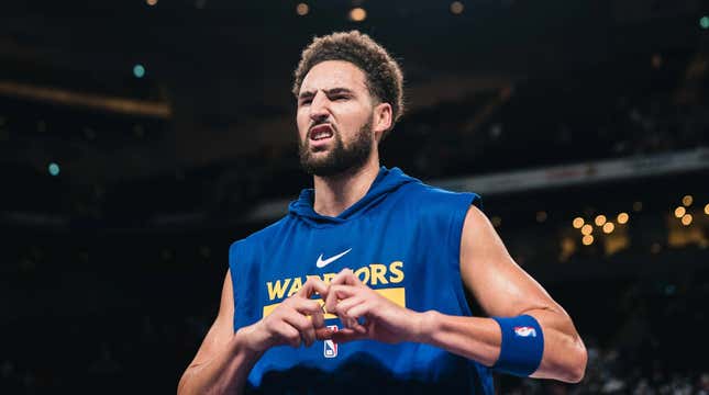 An NBA pro makes a heart shape with his hands. 