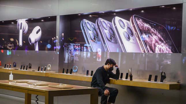 A Chinese employee with a protective mask sits in an Apple store in Beijing, China. Apple announced that it was closing its stores, offices and contact centers in the region following the coronavirus outbreak.