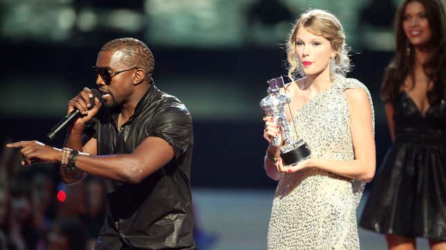 Kanye West (L) jumps onstage after Taylor Swift (C) won the “Best Female Video” award during the 2009 MTV Video Music Awards on September 13, 2009, in New York City. 