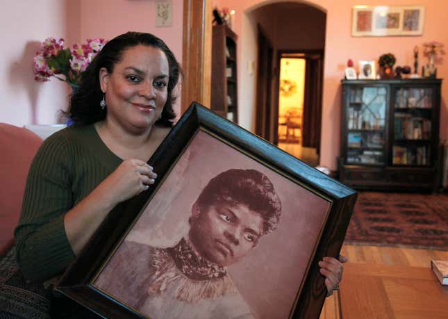 Michelle Duster poses with a portrait of her great-grandmother, Ida B. Wells, in her home on Chicago’s South Side.
