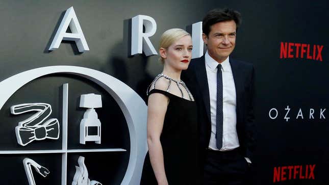 Jason Bateman and Julia Garner pose in front of the logo for the Netflix series "Ozark"