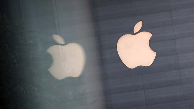 The apple logo being reflected on a shining surface