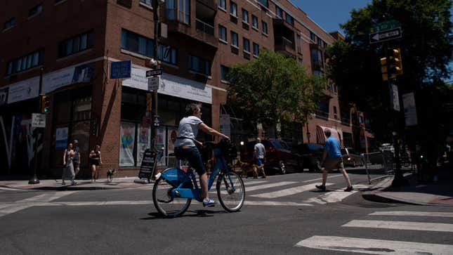 A bicyclist and pedestrians cross the intersection of South and 3rd Streets in Philadelphia, Pennsylvania.