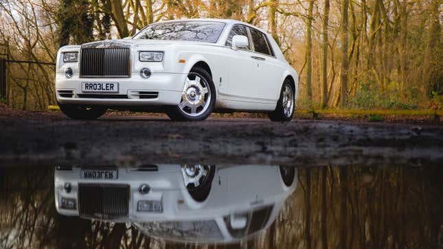 A photo of a white Rolls Royce with dirt on it. 
