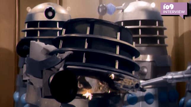 Two Daleks examine the destroyed corpse of one of their own in a colorized scene from their debut Doctor Who story, "The Daleks."