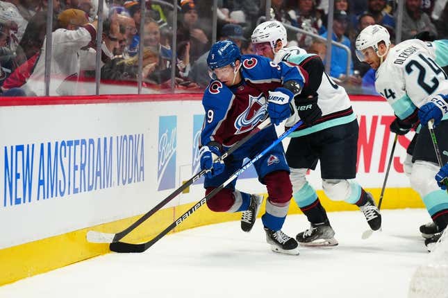 Apr 18, 2023; Denver, Colorado, USA; Colorado Avalanche center Evan Rodrigues (9) and Seattle Kraken center Morgan Geekie (67) battle for the puck during the second period in game one of the first round of the 2023 Stanley Cup Playoffs at Ball Arena.