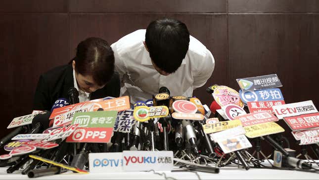 Kai Ko and his agent bow at a press conference on his arrest for marijuana use.