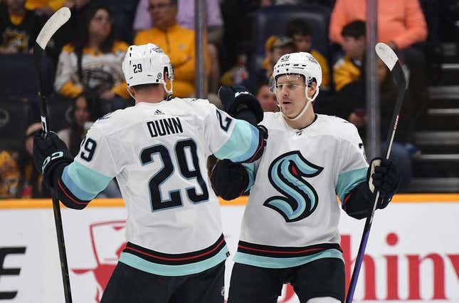 Mar 25, 2023; Nashville, Tennessee, USA; Seattle Kraken right wing Eeli Tolvanen (20) celebrates with defenseman Vince Dunn (29) after a goal during the first period against the Nashville Predators at Bridgestone Arena.