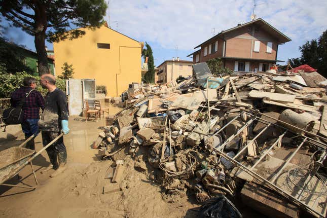 Photo of household items piled up amid mud