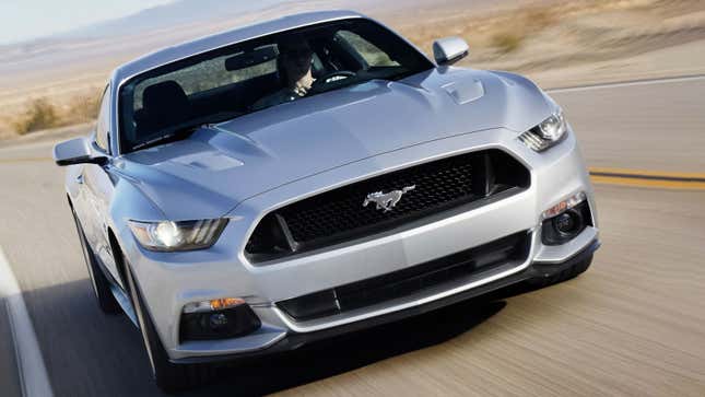 A photo of a silver Ford Mustang coupe driving on a highway. 