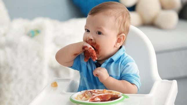Baby eating messily in high chair