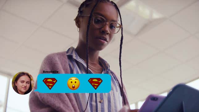 DC and the CW's live action Naomi wears glasses and is looking down at a text featuring Superman emoji.