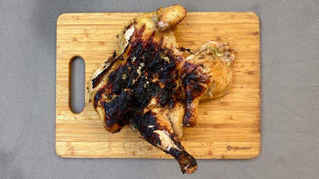 Aerial view of spatchcocked grilled chicken on a wooden cutting board