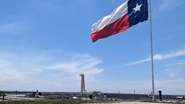 The Texas flag flies over the Circuit of the Americas, with the observation tower visible in the background