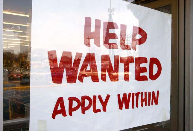 A sign on a storefront that reads "help wanted apply within"