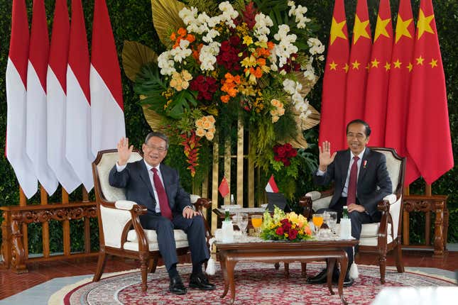 Chinese Premier Li Qiang, left, and Indonesian President Joko Widodo wave at reporters during their meeting at Merdeka Palace in Jakarta, Indonesia, Friday, Sept. 8, 2023. (AP Photo/Achmad Ibrahim)