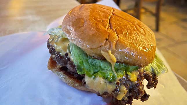 Homemade burger sitting on its wrapper.