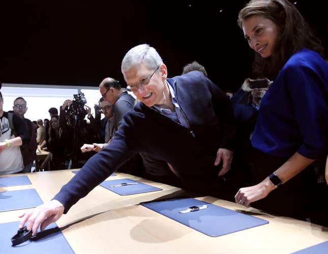 Apple CEO Tim Cook reaches for an Apple Watch in San Francisco.