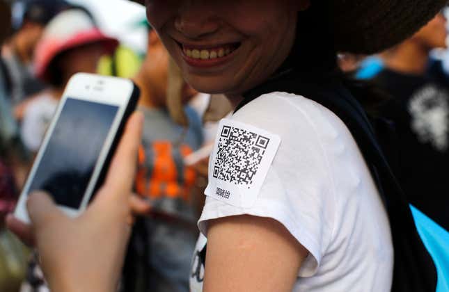 A man gets a woman’s contact information by snapping a photo of her QR code.