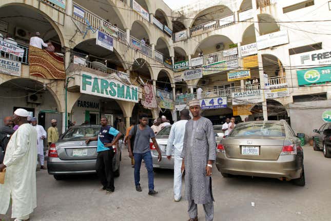 People stand at a complex with bureau de change operators in Abuja.