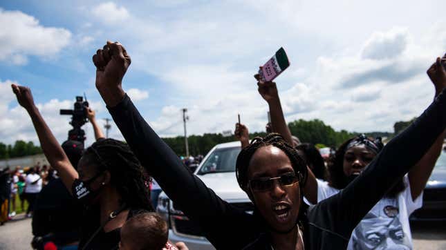 Members of the crowd cheer when a group of black motorcyclists circled the street outside a memorial and public viewing for George Floyd on June 6, 2020 in Fayetteville, North Carolina.