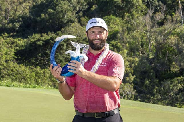January 8, 2023; Maui, Hawaii, USA; Jon Rahm hoists the trophy on the 18th hole during the final round of the Sentry Tournament of Champions golf tournament at Kapalua Resort - The Plantation Course.