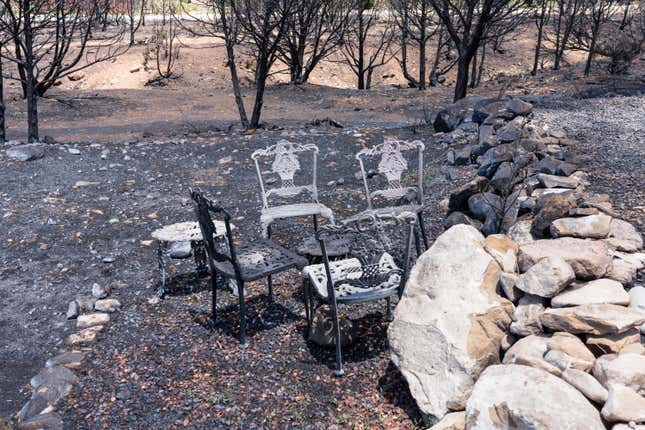 empty outdoor chairs sit on wildfire burn area