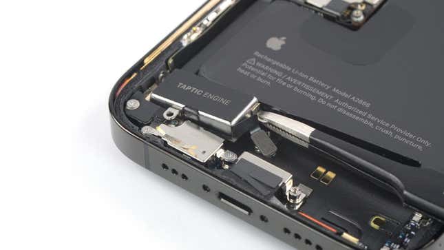 An open iPhone 14 with a taptic engine replacement part.