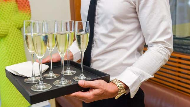 server holding tray of prosecco