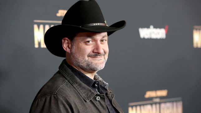 Dave Filoni, wearing his cowboy hat, smiles smugly.