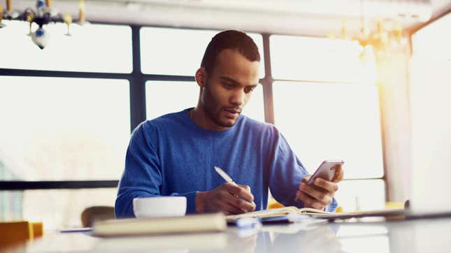 man studying with notes and smartphone