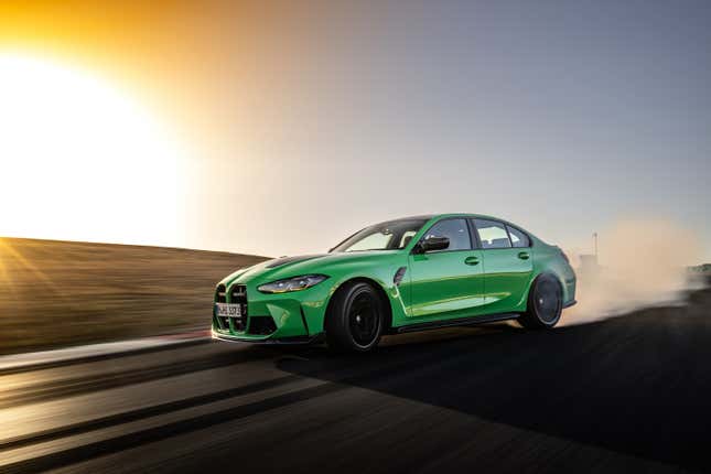 A bright green 2024 BMW M3 CS drifts on a race track with a big cloud of tire smoke behind it.