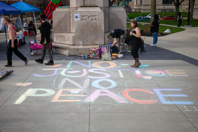Protesters write messages in sidewalk chalk at Veterans Park before a march through downtown Grand Rapids, Mich., on Saturday, April 23, 2022. The march was organized by the Breonna Taylor Foundation in response to the April 4 shooting death of Patrick Lyoya by a Grand Rapids police officer.