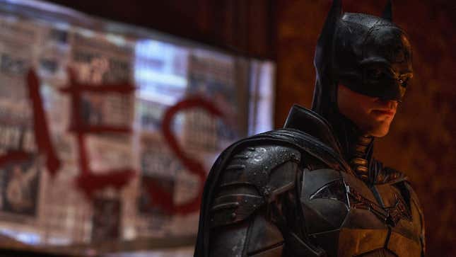 Robert Pattinson brooding in costume as Batman in The Batman.