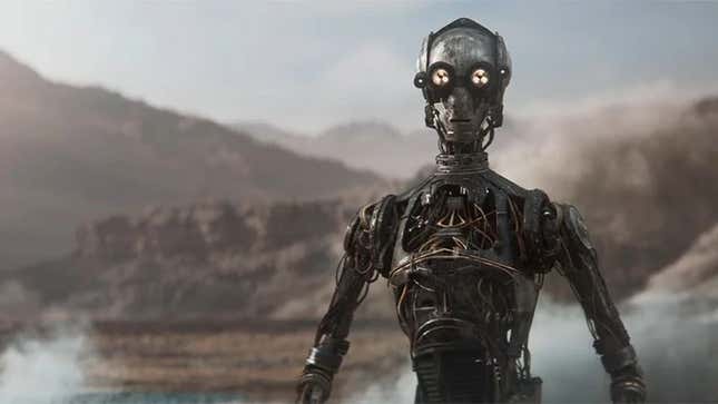 A droid without any plating or outside covering stares at the camera on a desert world.