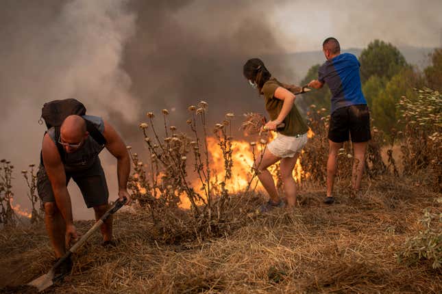 Residents of Sant Fruitós del Bages, Catalonia, Spain work together to extinguish a wildfire on July 17, 2022.
