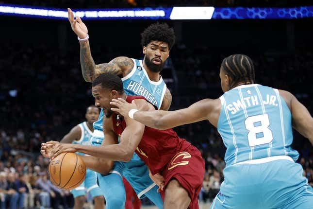 Mar 12, 2023; Charlotte, North Carolina, USA; Cleveland Cavaliers forward Evan Mobley (4) drives through Charlotte Hornets guard Dennis Smith Jr. (8) and center Nick Richards (4) during the first half at Spectrum Center.
